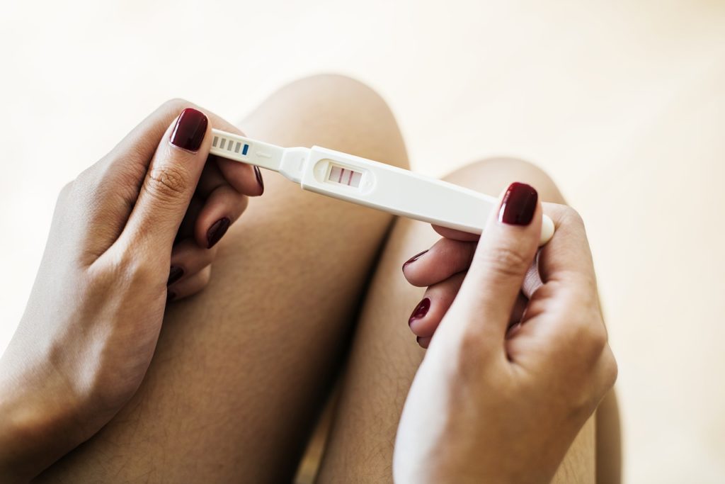 woman holding a pregnancy test with 2 lines