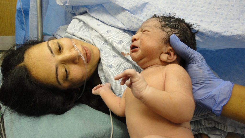 Newborn baby being shown to mum